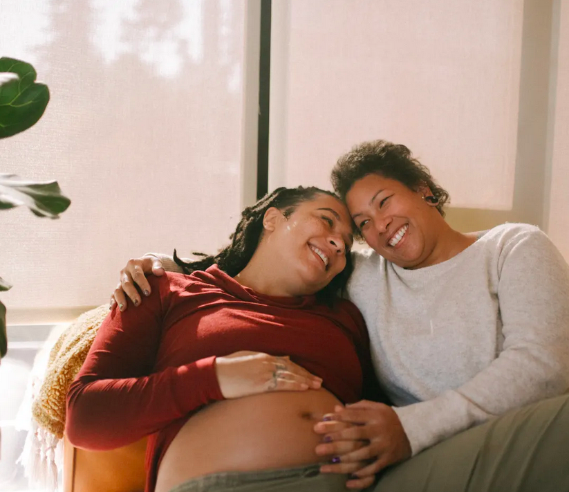 Expecting parents standing next to crib